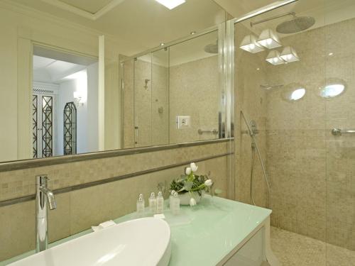 a bathroom with a sink and a shower and a mirror at Hotel Villa Athena in Agrigento