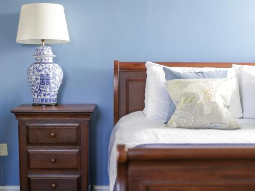 a bed with a nightstand with a lamp on it at The Speech House in Coleford