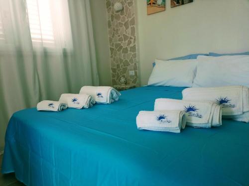 a blue bed with blue and white towels on it at BlueSun Apartments in Leporano Marina