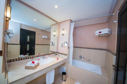 a bathroom with a sink and a large mirror at Zalagh Kasbah Hotel & Spa in Marrakech