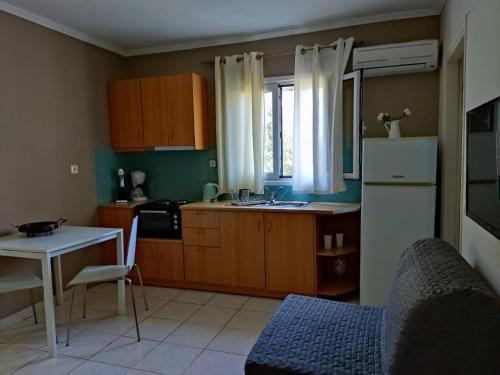 een keuken met een koelkast, een tafel en een wastafel bij Morfi in Lefkada