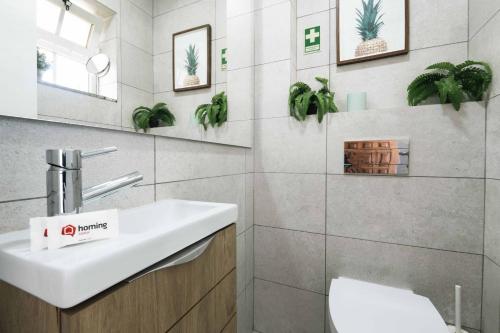 a bathroom with a sink and plants on the wall at Sesimbra Stylish Villa by Homing in Sesimbra