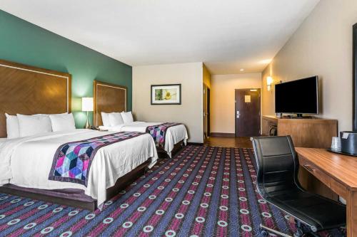 a hotel room with two beds and a flat screen tv at Comfort Inn & Suites Newcastle - Oklahoma City in Newcastle