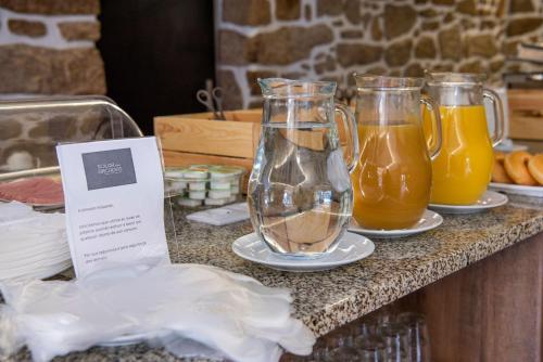 a table with two glasses and two pitchers of juice at Hotel Rural Solar das Arcadas in Ponte de Lima