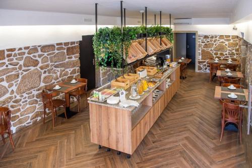 a restaurant with a counter with tables and chairs at Hotel Rural Solar das Arcadas in Ponte de Lima