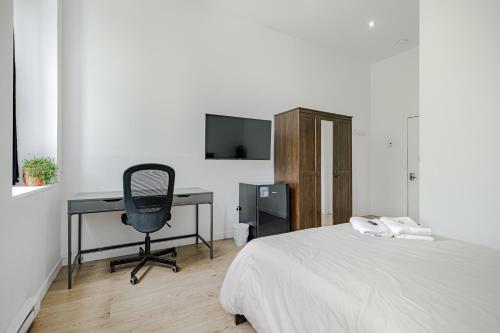 a bedroom with a bed and a desk and a chair at HoMa Homestay Hotel by Olympic Stadium Montreal Auberge-Hostel in Montréal