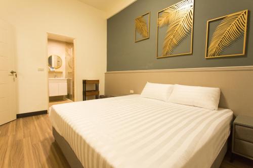 sypialnia z dużym łóżkiem z dwoma obrazami na ścianie w obiekcie 喜苑民宿 w Jinhu