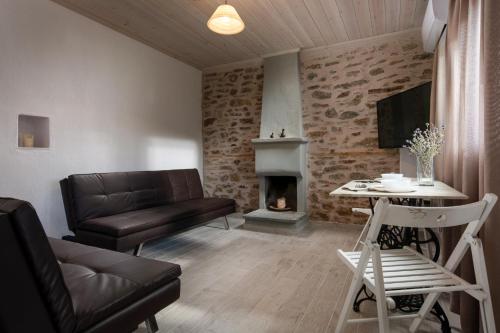 a living room with a couch and a fireplace at Agrikia tis Vasilikis in Ormília
