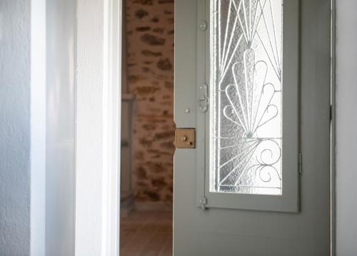 a white door with a etched glass window at Agrikia tis Vasilikis in Ormília