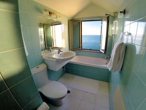a bathroom with a sink and a toilet and a bath tub at Finest Rentals - Beachfront Penthouse in Funchal