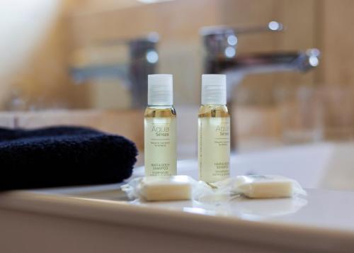 two bottles of soap sitting on a bathroom sink at Hotel Aqua Sárvár in Sárvár