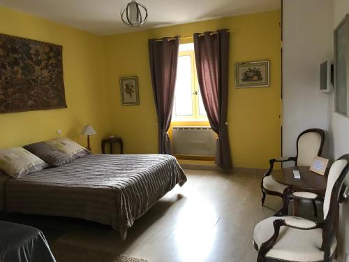 een slaapkamer met een bed, een raam en een stoel bij Chambre d'Hotes La Brunetière in Gréoux-les-Bains
