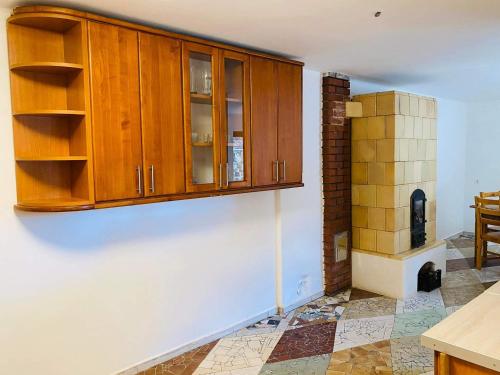 Felsőtold的住宿－Kontyos Vendégház，厨房配有木制橱柜和瓷砖地板。