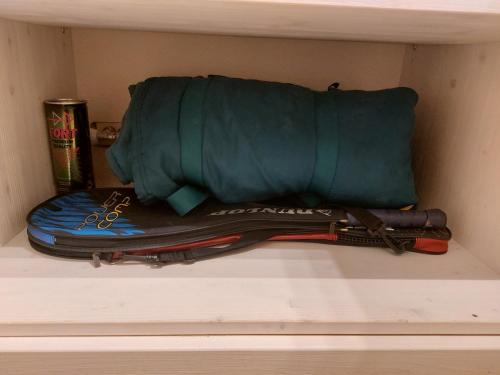 a shelf with a green bag and some other items at Italian Apartment with Hot Tub in Arabba