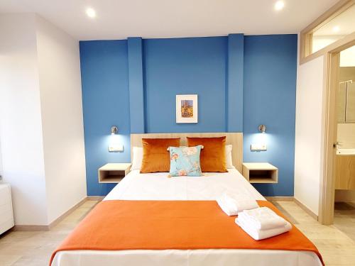 sypialnia z niebieskimi ścianami i dużym łóżkiem w obiekcie Inicia AVIO Apartamentos w Santiago de Compostela