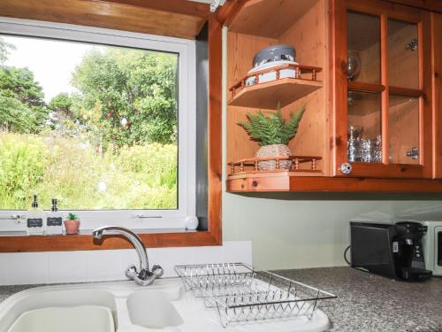 encimera de cocina con fregadero y ventana en Ceol-na-Mara, 