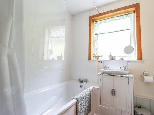a bathroom with a sink and a tub and a window at Ceol-na-Mara in Berriedale