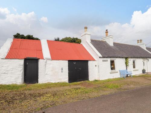 a white building with an orange roof and a red roof at Ceol-na-Mara in Berriedale