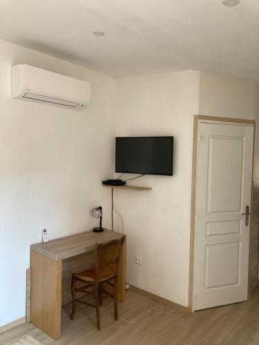 Cette chambre dispose d'un bureau et d'une télévision murale. dans l'établissement Appartement maisonnette de vacances, à Cannes