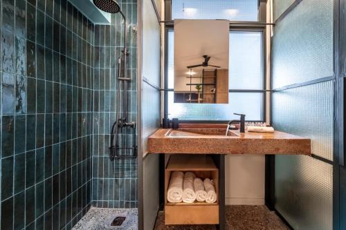 een badkamer met een wastafel en een douche met een spiegel bij Hidesign Athens The Getaway Apartments in Athene