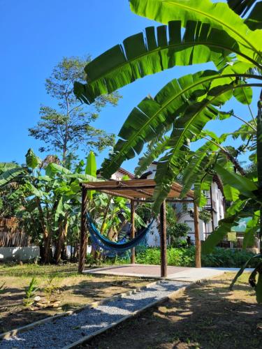 Pousada Tartarugas de Paúba في باوبا: أرجوحة في حديقة بها أشجار نخيل