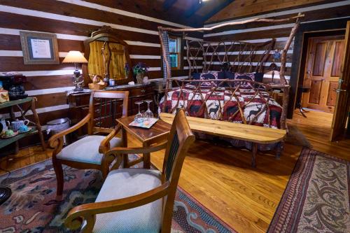 a bedroom with a bed and a table and chairs at Creekwalk Inn Bed and Breakfast with Cabins in Cosby