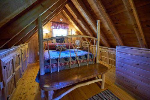 a bedroom in a cabin with a bed in it at Creekwalk Inn Bed and Breakfast with Cabins in Cosby