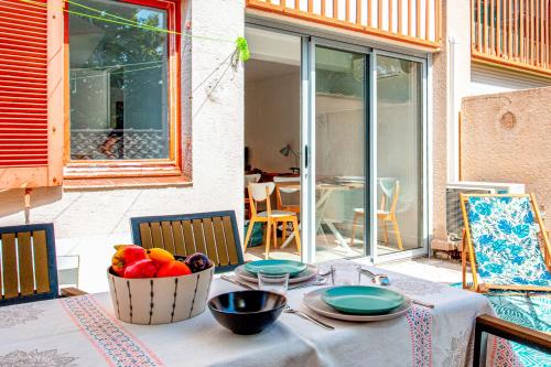 una mesa con un bol de fruta en el patio en Apartment with terrace facing the beach - Welkeys, en La Seyne-sur-Mer