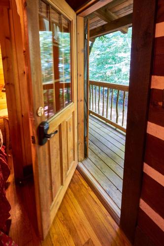 an open door of a cabin with a balcony at Creekwalk Inn Bed and Breakfast with Cabins in Cosby