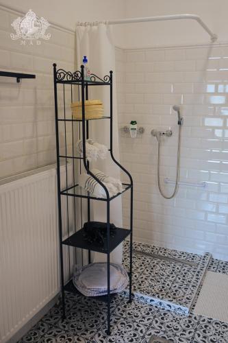 a black shelf in a bathroom with a shower at Érintés Vendégház in Tállya