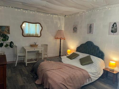 a bedroom with a bed and a table and a mirror at Number Four - The Old Stable Block in Wadebridge