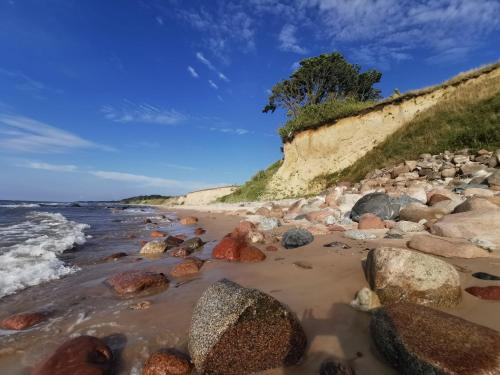 a beach filled with rocks and the ocean at Brīvdienu mājas Lejnieki in Strante