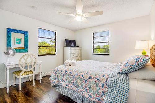 a bedroom with a bed and a desk and windows at Beach to Bay Getaway in Anna Maria