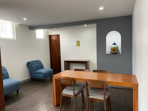 a waiting room with a wooden table and chairs at Hotel Menara in Mexico City