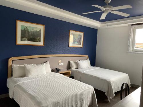 1 dormitorio con 2 camas y ventilador de techo en Hotel Menara, en Ciudad de México