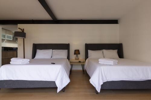 two beds sitting next to each other in a room at El Doce by HomiRent in Laborcillas