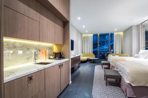 マイアミにあるSuites at SLS Lux Brickell managed by CEのベッド2台とシンク付きのホテルルームです。