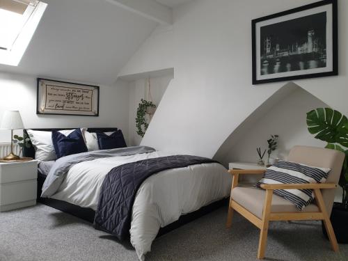 a bedroom with a bed and a chair at Tropicana House in Barnsley