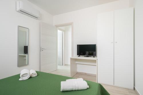 カステッランマーレ・デル・ゴルフォにあるVilla Essenzaの白い部屋(ベッド1台、テレビ付)