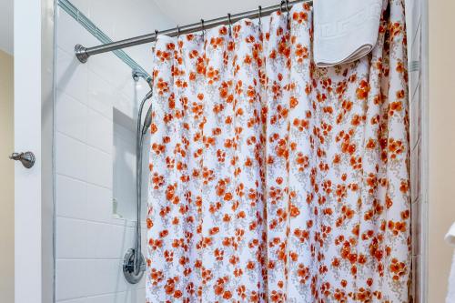 a shower curtain with orange flowers on it in a bathroom at Cedar Oasis in Ventura