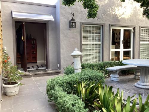 a patio with a table and a bench in front of a house at Villa Lyrique in Cape Town