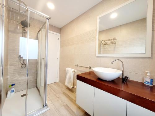 a bathroom with a sink and a glass shower at Acogedor apartamento a la entrada de camino portugués in Santiago de Compostela