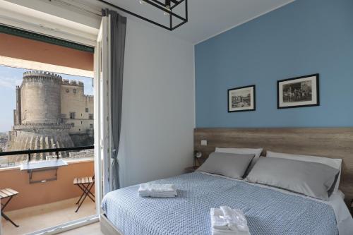 um quarto com uma cama e uma grande janela em AnGiò holiday rooms em Nápoles