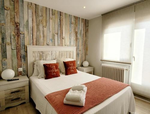 a bedroom with a white bed with red pillows at Acogedor apartamento a la entrada de camino portugués in Santiago de Compostela