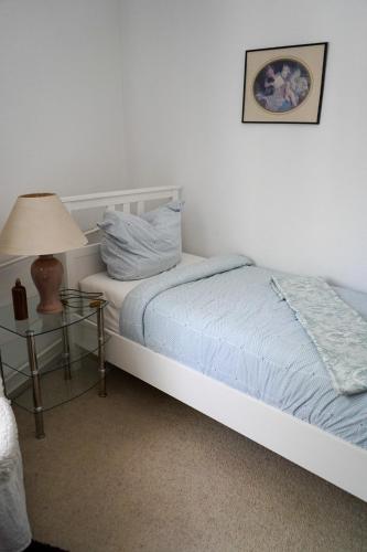 a bedroom with a bed and a table with a lamp at Cafe Alice & Pension GmbH in Potsdam