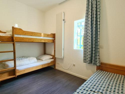 une chambre avec deux lits superposés et une fenêtre dans l'établissement Duplex lumineux 6 pers · Au pied des pistes · Terrasse Sud · Accès piscine, spa et sauna - FR-1-425-133, à Flaine