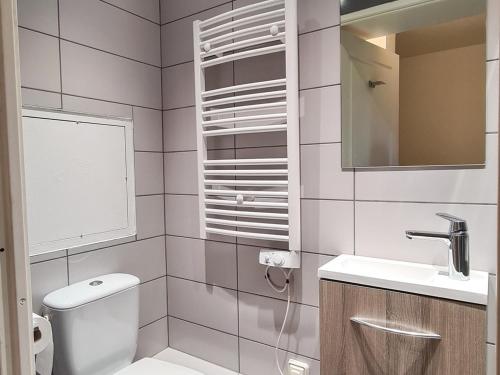 une salle de bain avec toilettes, lavabo et miroir dans l'établissement Duplex lumineux 6 pers · Au pied des pistes · Terrasse Sud · Accès piscine, spa et sauna - FR-1-425-133, à Flaine