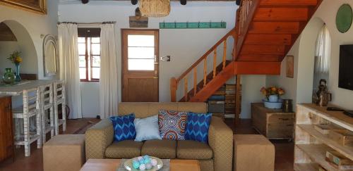 a living room with a couch and a staircase at StarFish Accommodation in Struisbaai