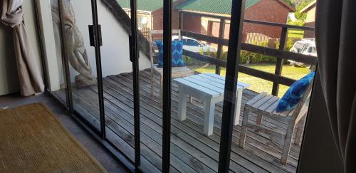 a screened in porch with a bench on the deck at StarFish Accommodation in Struisbaai