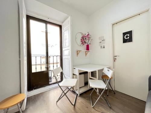 a room with a desk and chairs and a window at Ile Aina Exterior in Madrid